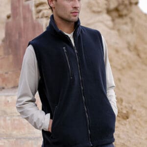 Model w polarowej kamizelce fason VKM-12 z trzema kieszeniami zapinanymi na zamek, kamizelka rozpinana na całości