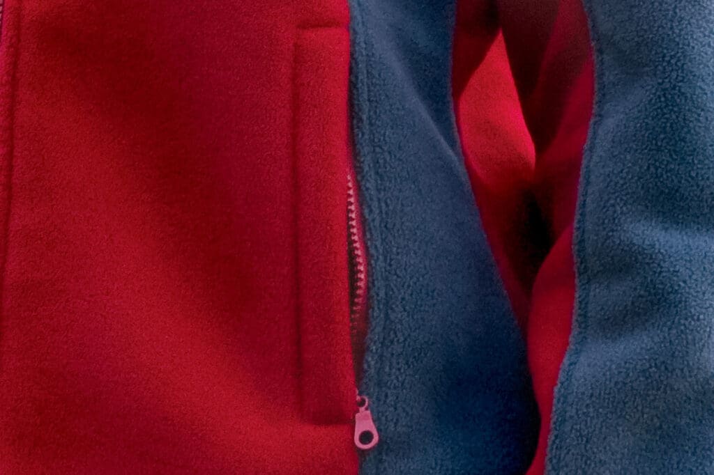 Zbliżenie na kieszeń w polarze fason VPL-10d, kieszeń zapinana na zamek z patką.