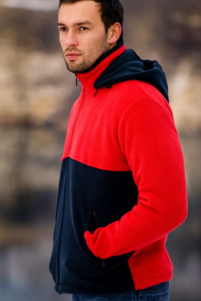 Model w polarze rozpinanym, fason VPL-19, przykładowa kolorystyka czarno-czerwony, dopinany kaptur, kieszenie zapinane na zamek.